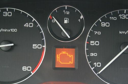 Photo montrant le compteur d'un véhicule avec un logo moteur au centre